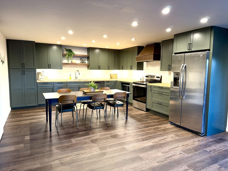 Chef-worthy kitchen equipped with stainless steel appliances, butcher block counters, and a spacious dining table for the whole group.