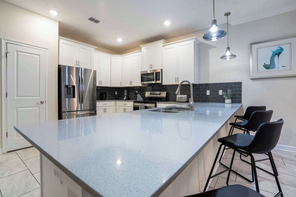 Modern kitchen with a large quartz island and stainless steel appliances