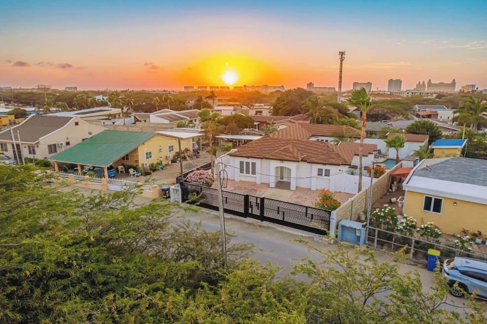 Elevated neighborhood view at sunset with warm tones, rooftops, and a calm residential atmosphere