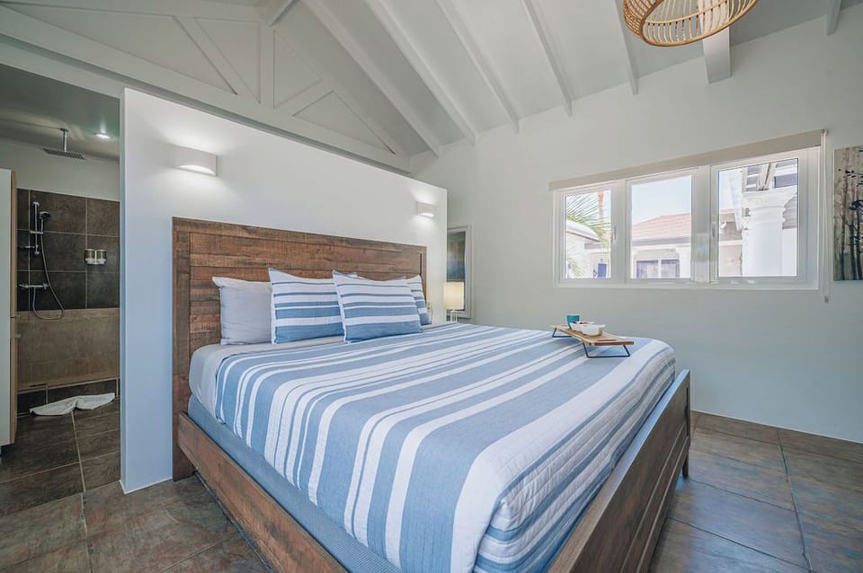 Wide bedroom view with king bed, clean lines, and bright windows enhancing the airy layout