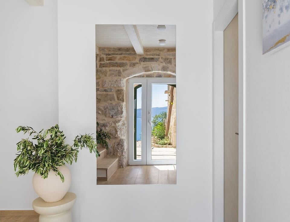 An internal staircase connects all levels of the villa, featuring charming stone walls and sea views.