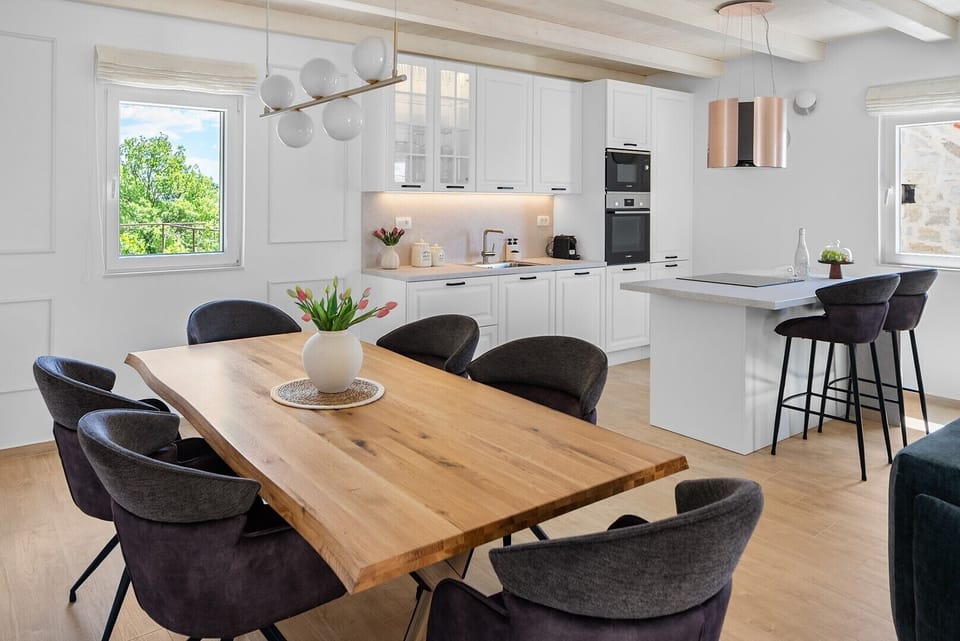 A spacious dining area includes a large table that comfortably seats up to 6 guests.
