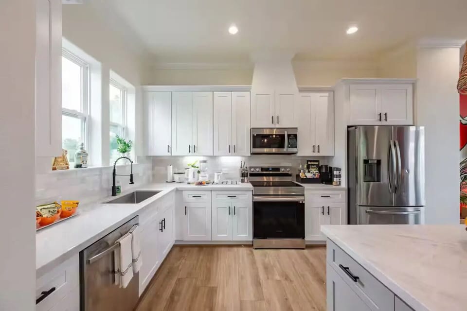 Modern stainless steel appliances match perfectly with the white cabinets.