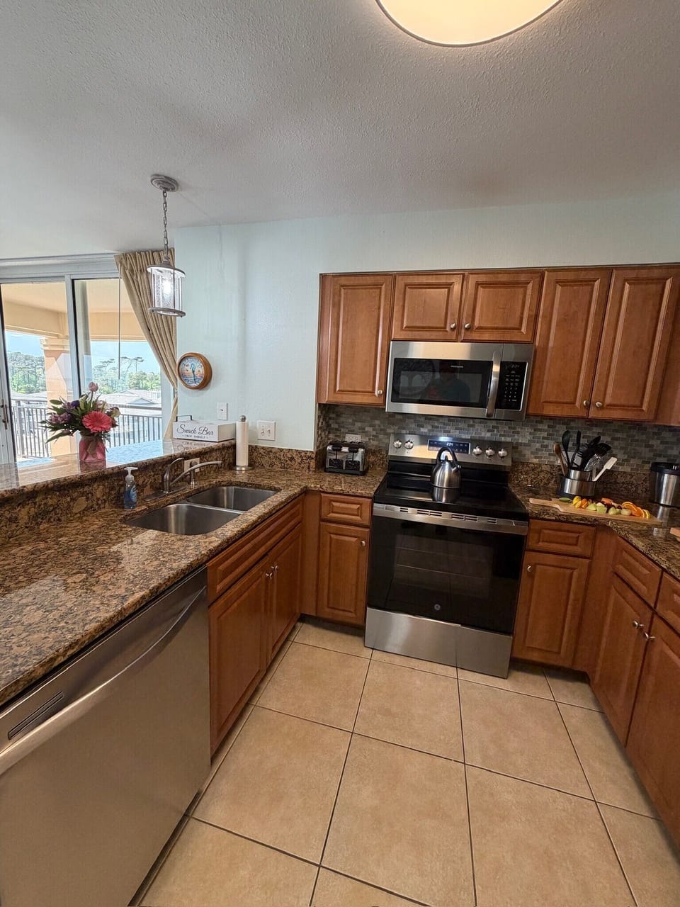 You'll love preparing meals in this fully equipped kitchen featuring granite countertops, stainless steel appliances, and warm wood cabinetry.
