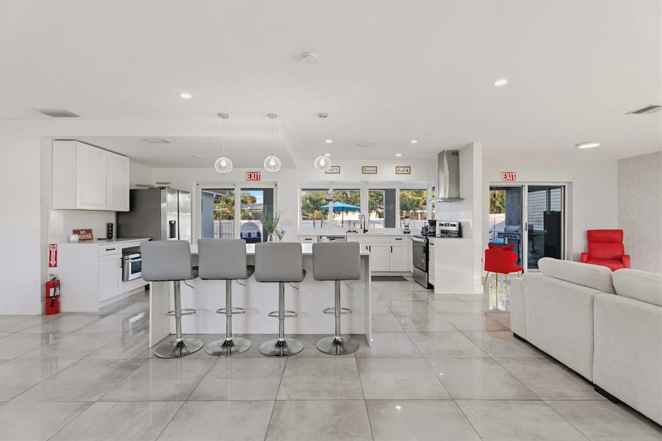 Gourmet chef's kitchen featuring a large waterfall island and sleek breakfast bar seating.