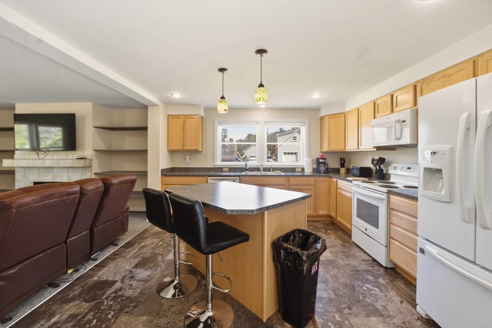 Your spacious kitchen features granite counters, modern appliances, and a breakfast bar where you can sip coffee while planning your day's adventures.