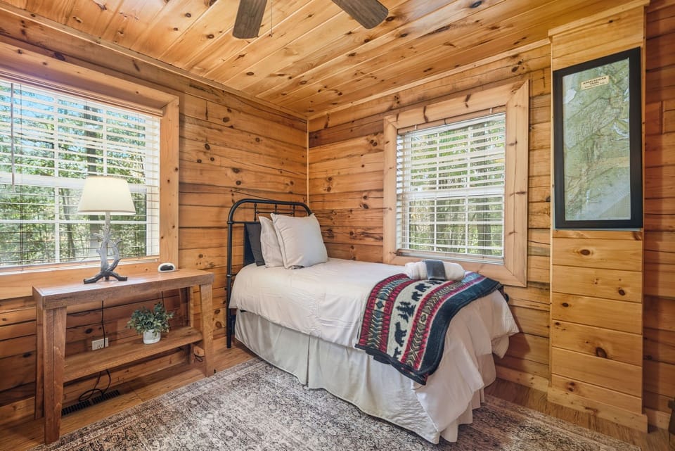 Inviting bedroom retreat with cozy bedding and woodland views.