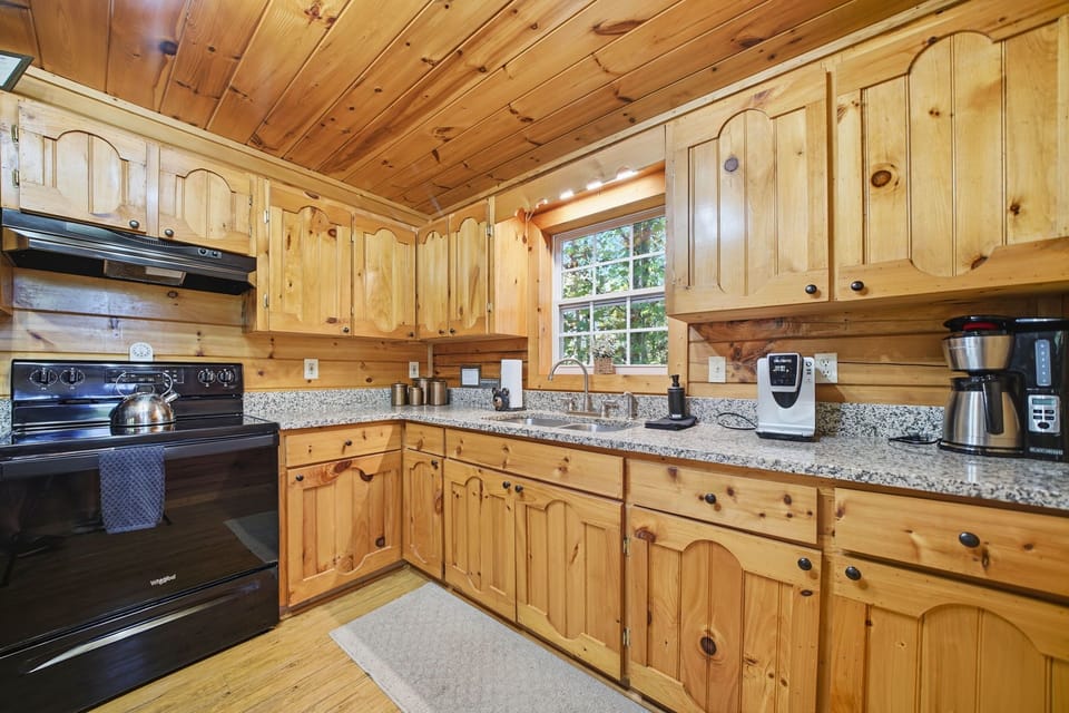 Fully equipped kitchen with granite countertops and warm cabin finishes.
