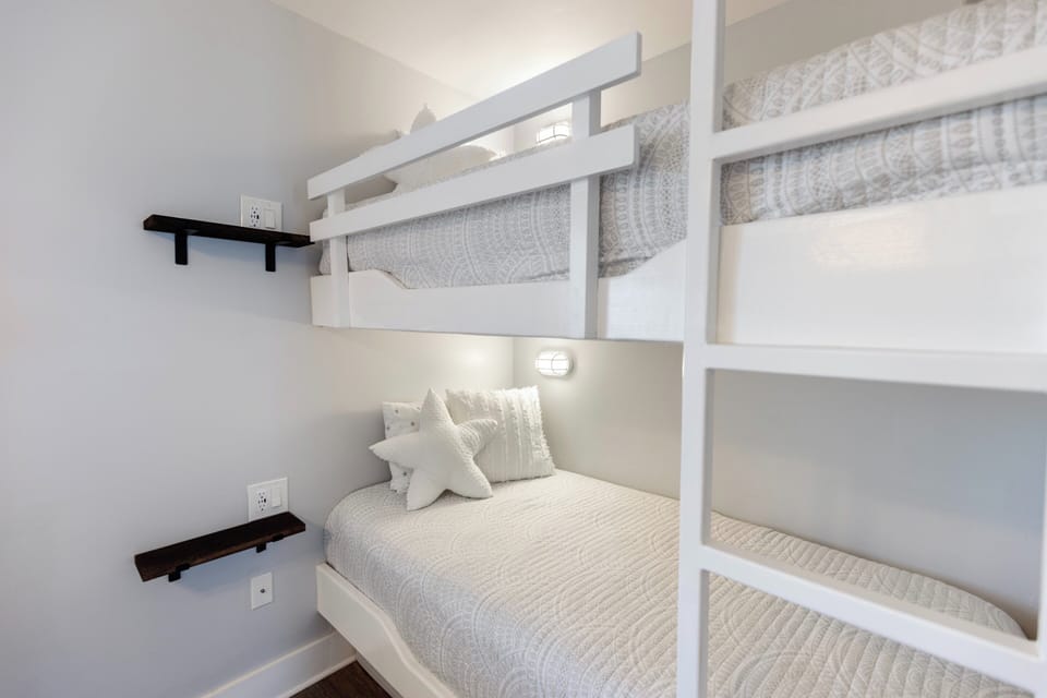 Your cozy bunk room features built-in beds with personal reading lights and convenient shelving for a comfortable night's rest.