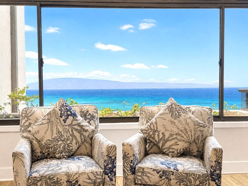 Natural light fills the living space, with the ocean as a constant backdrop through floor-to-ceiling glass