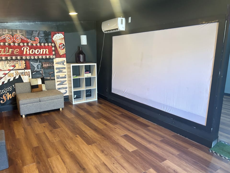 Private home theater room with large projector screen for cozy movie nights
