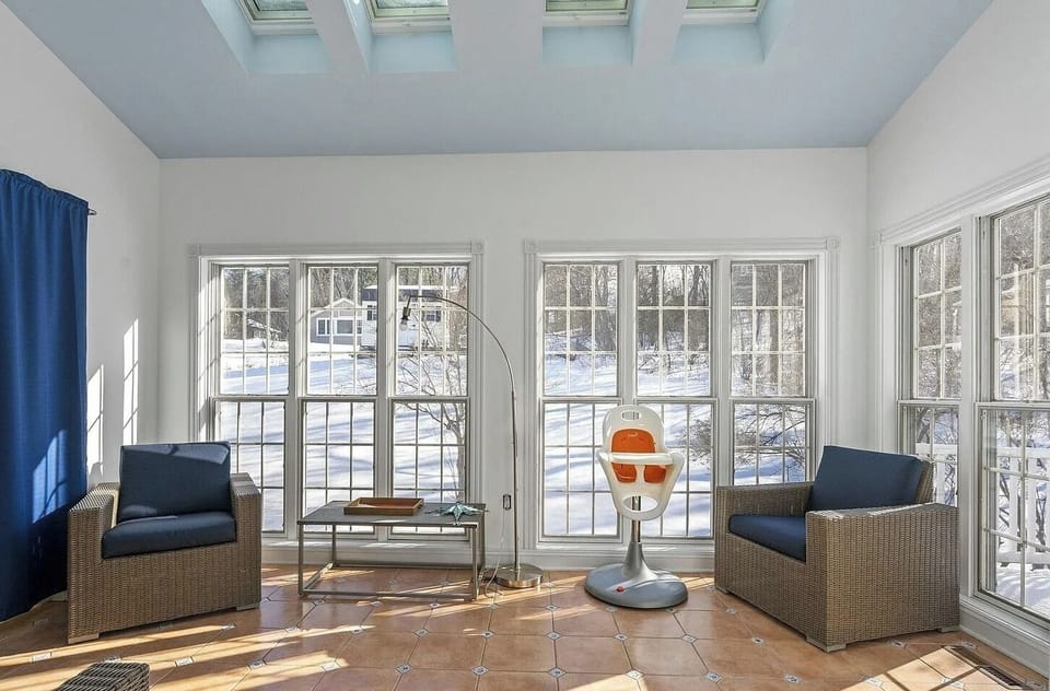 This bright and inviting sunroom offers a peaceful space for morning coffee, reading, or relaxing conversations with friends and family.
