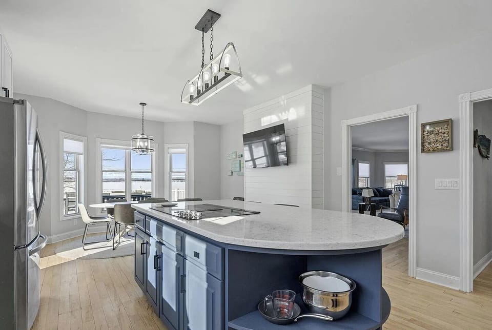 This open, light-filled kitchen combines spacious island seating, a charming breakfast area, ad breathtaking lakefront views from nearly every angle.