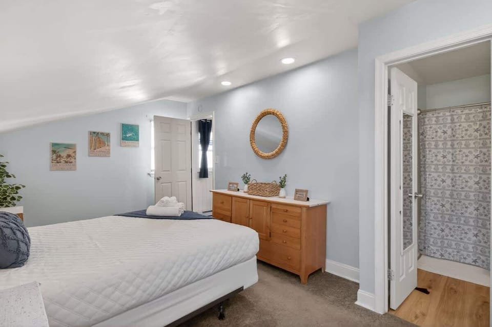 Spacious bedroom with a comfortable bed, dresser storage, and easy access to the bathroom—designed for comfort and convenience during your stay.
