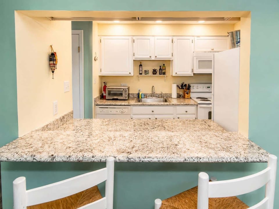 Spacious kitchen with granite breakfast bar, open pass-through design, and modern finishes—perfect for casual dining and entertaining.