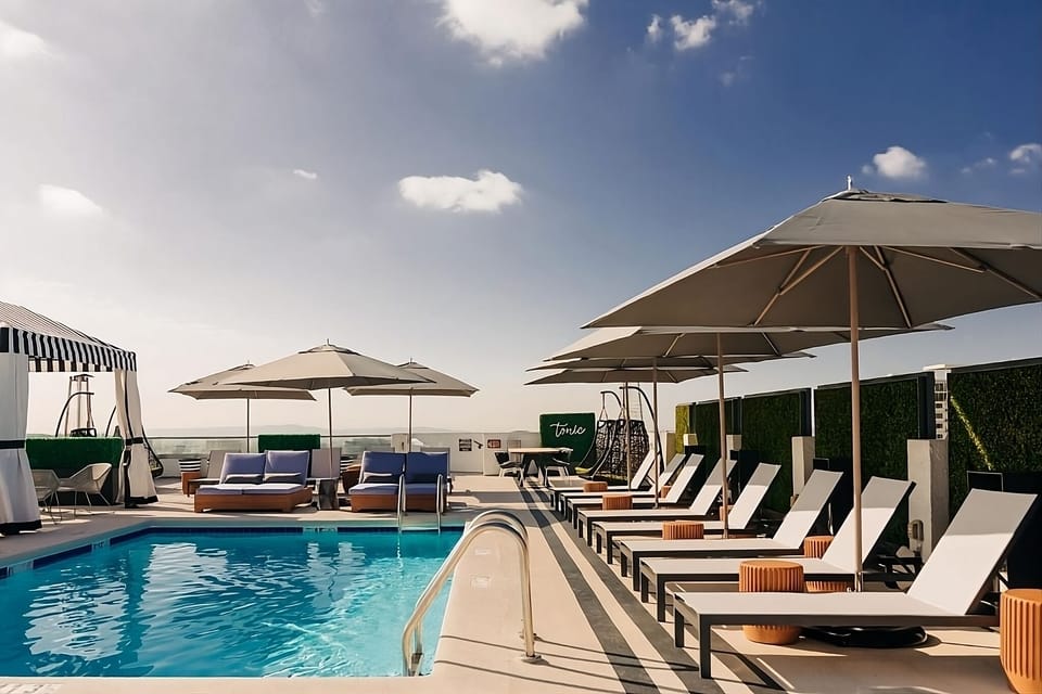 Unwind poolside under oversized umbrellas with resort-style loungers.