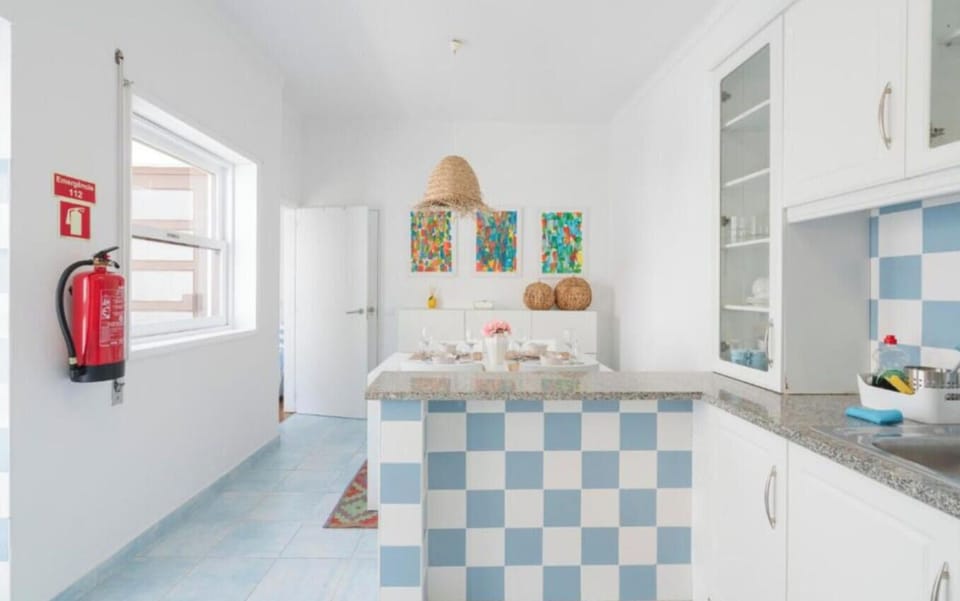 Bright kitchen with blue-and-white tile design and granite countertops
