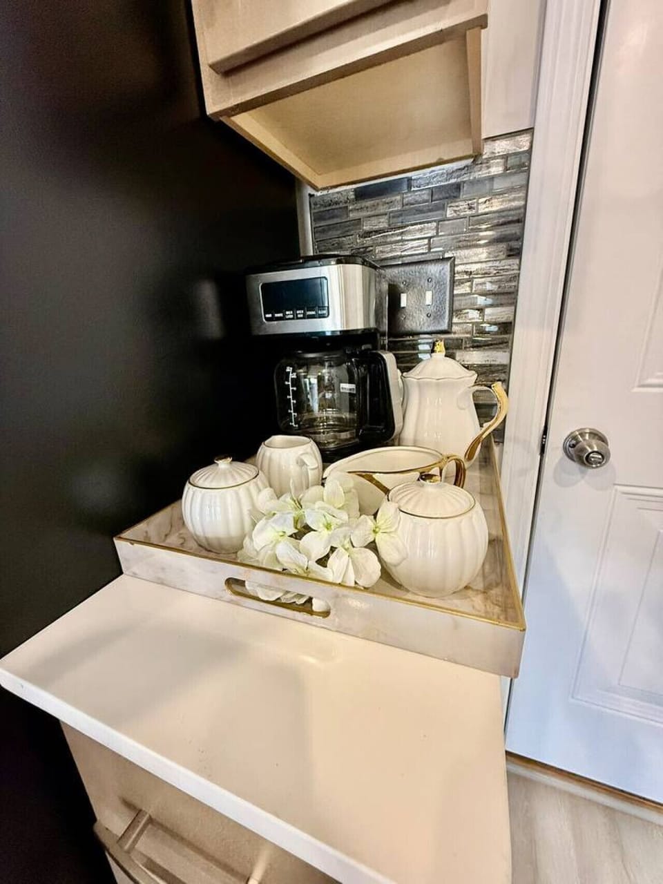 Charming coffee station with coffee maker and elegant decorative accents.