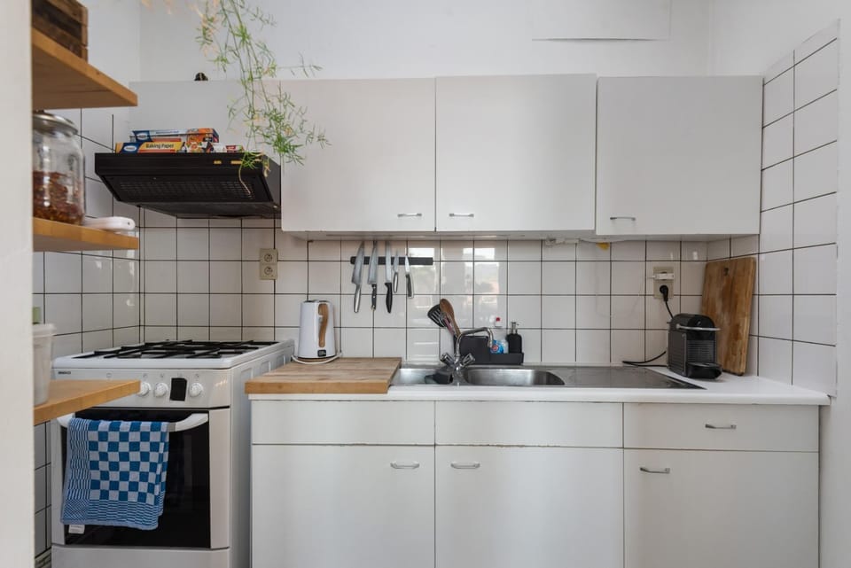 Compact and functional kitchen equipped with a gas stove, sink, and essential cooking tools. Clean countertops and practical storage make it easy to prepare meals during your stay.
