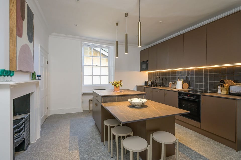 Contemporary kitchen with integral appliances, a central island and fitted breakfast bar
