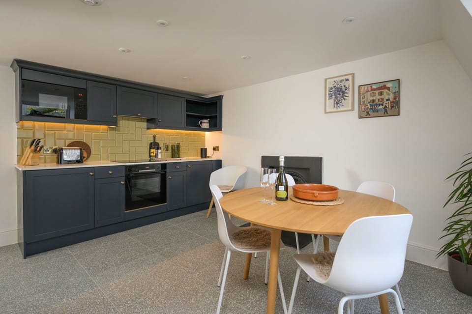 Contemporary kitchen with integral appliances and a dining area