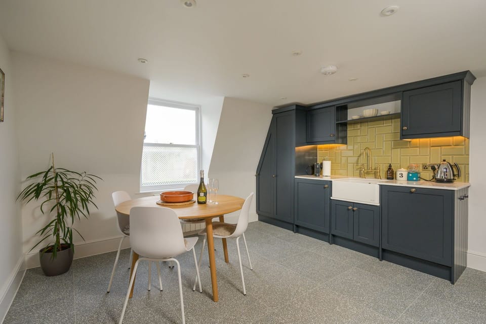 Contemporary kitchen with integral appliances and a dining area