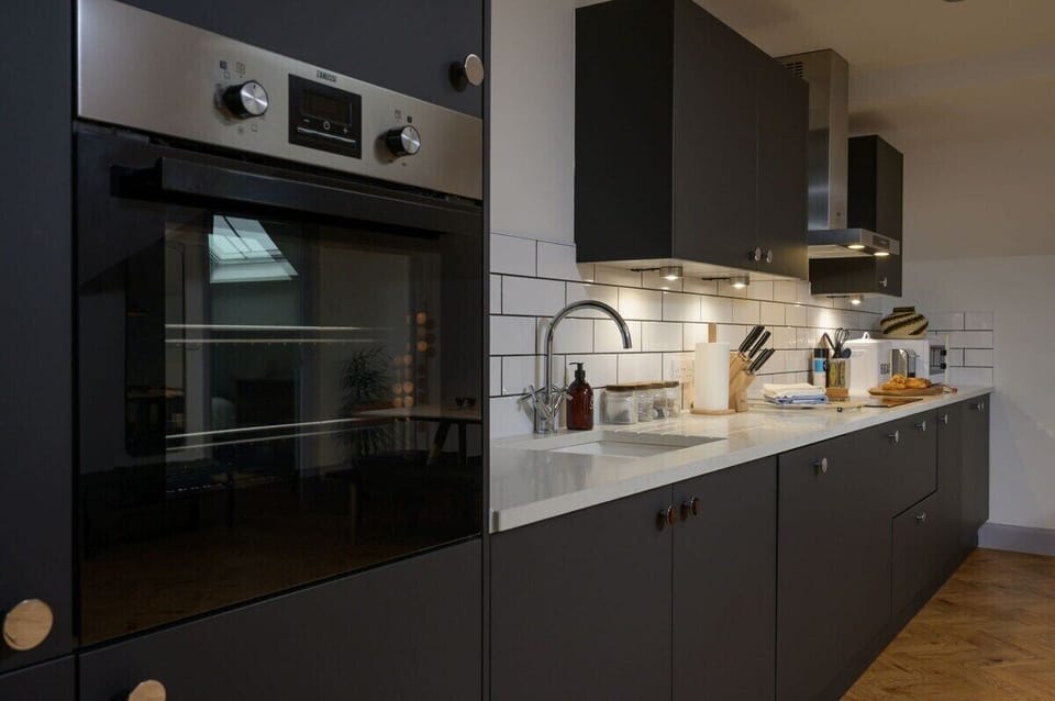 Contemporary fitted kitchen with stone work surfaces and integral appliances