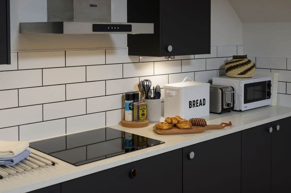 Contemporary fitted kitchen with stone work surfaces and integral appliances