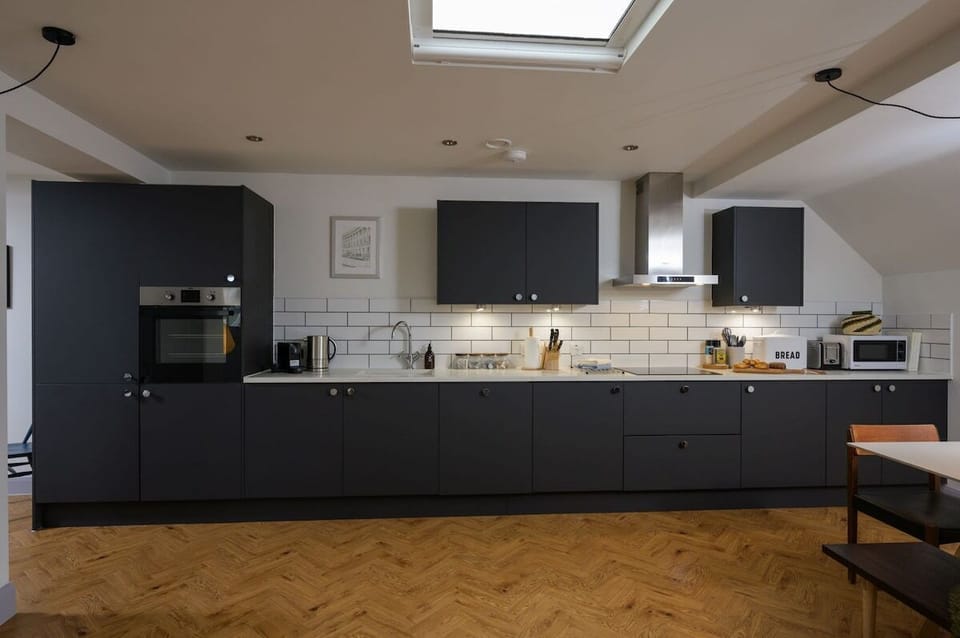 Contemporary fitted kitchen with stone work surfaces and integral appliances