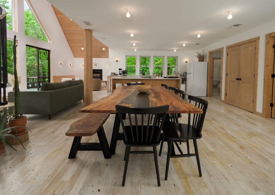 Dining Area: Gather around the stunning wood table with views of lush greenery outside!