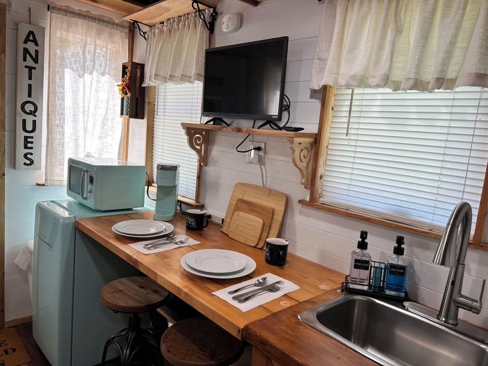 The kitchenette with a mini fridge, microwave, coffee maker,  and Smart TV.