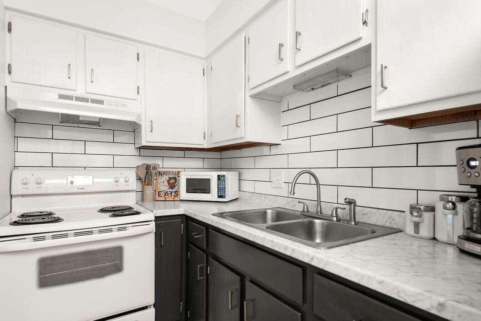 A clean kitchen with white appliances and subway tile makes meal prep easy.