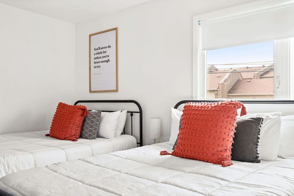 Rich terracotta pillows and a warm gray velvet couch create a living space that feels both bold and cozy.