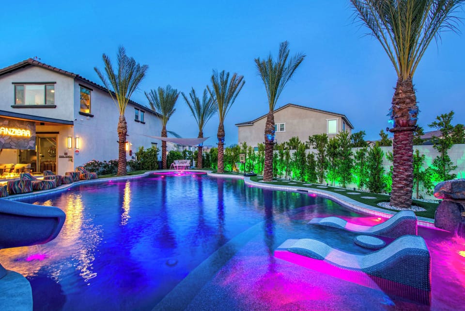 Your private resort awaits. Enjoy a sparkling pool with a Baja shelf, in-water loungers, vibrant LED lighting, and towering palms—perfect for unforgettable days and magical evenings.