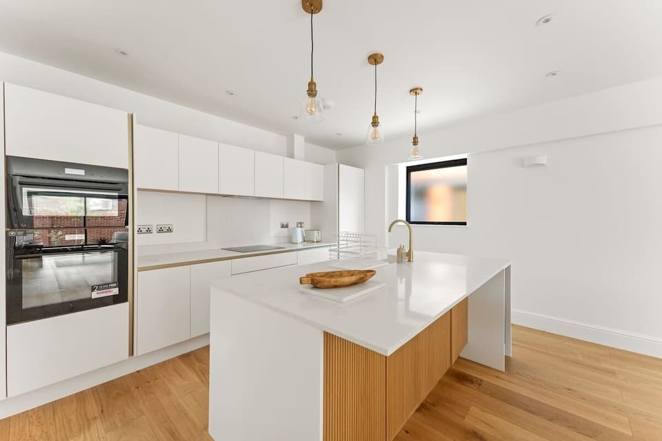 Spacious kitchen layout with island and elegant hanging light fixtures
