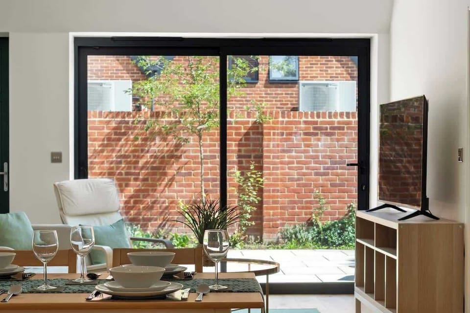 Dining table near window with garden view and natural sunlight
