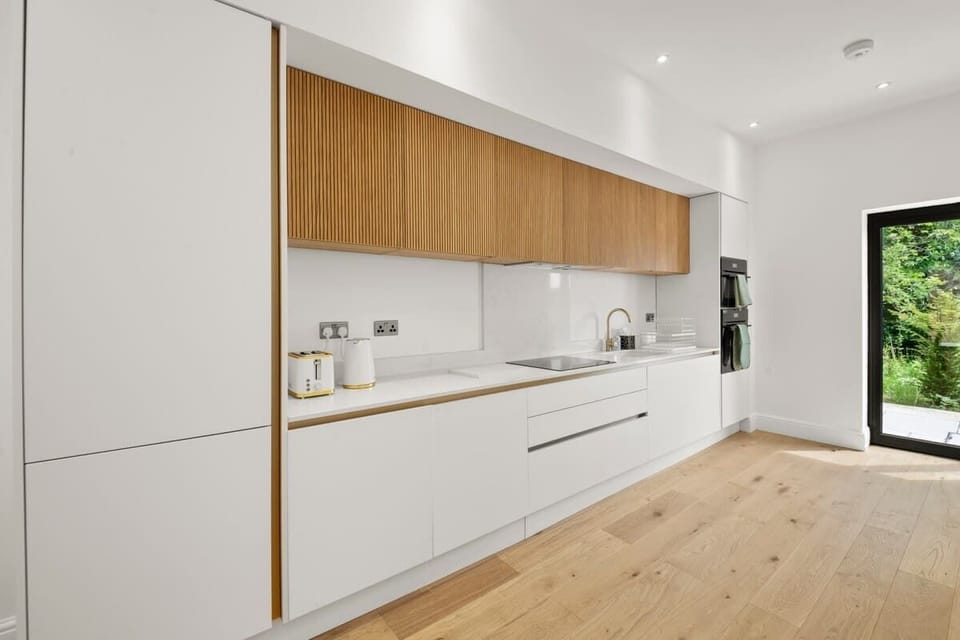 Open plan kitchen with wood accents lines and bright lighting
