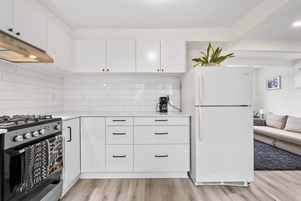 Modern Kitchen: Sleek white cabinetry and a gas stove await your culinary adventures!