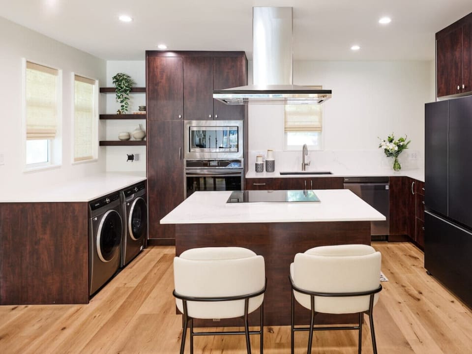 Modern kitchen with island seating and full appliances.