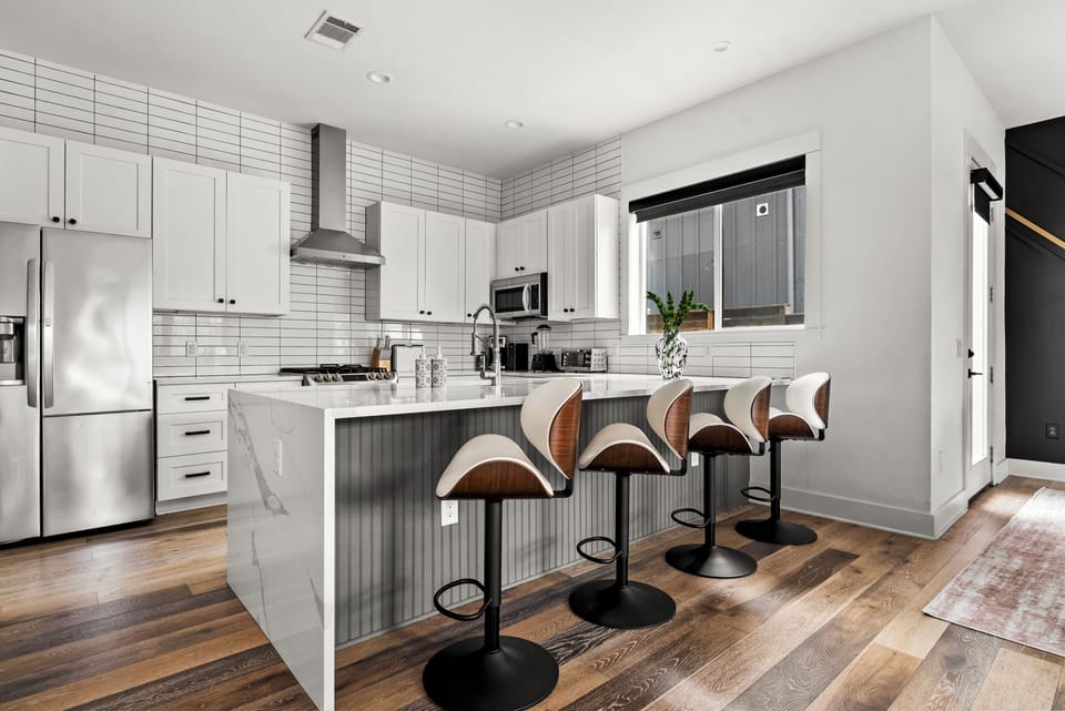 Bright modern kitchen with waterfall island and seating for four