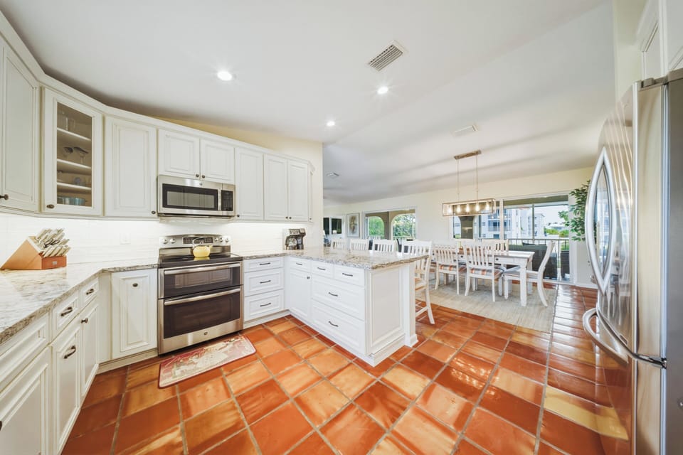Enjoy cooking with breathtaking water views in this open-concept kitchen and dining space. Located in Marathon, Florida, this waterfront vacation rental offers a private pool and seamless indoor-outdoor island living.