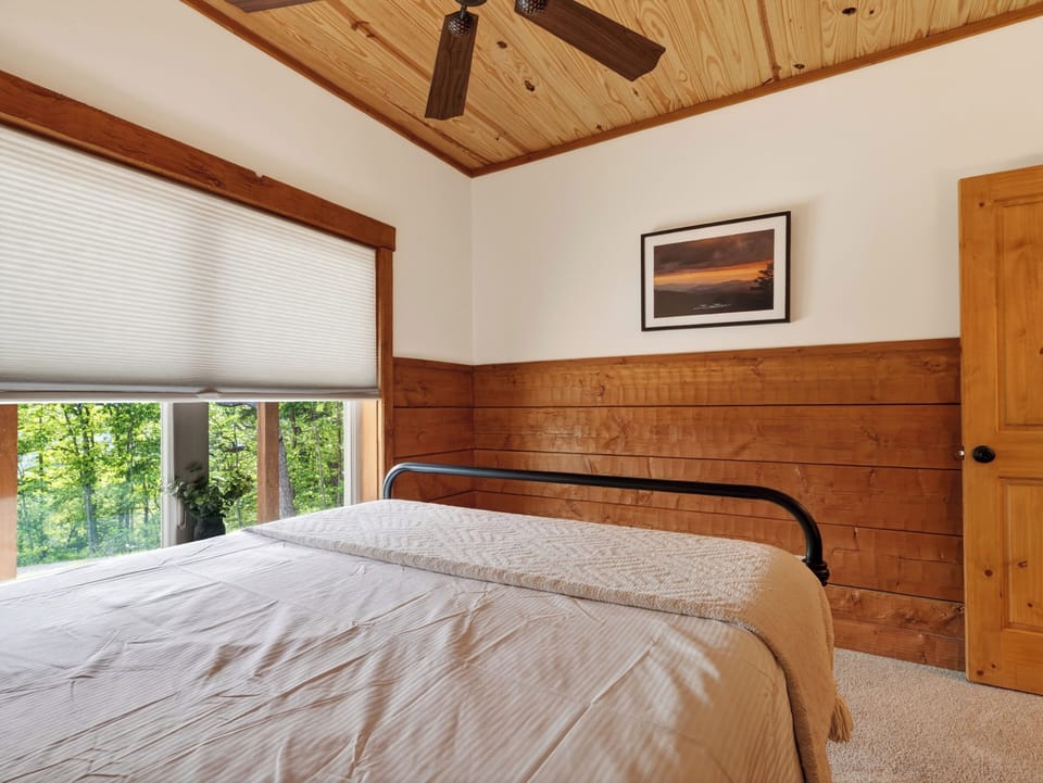 Bedroom 3 is located on the lower level, featuring a queen-size bed and an ensuite bathroom.