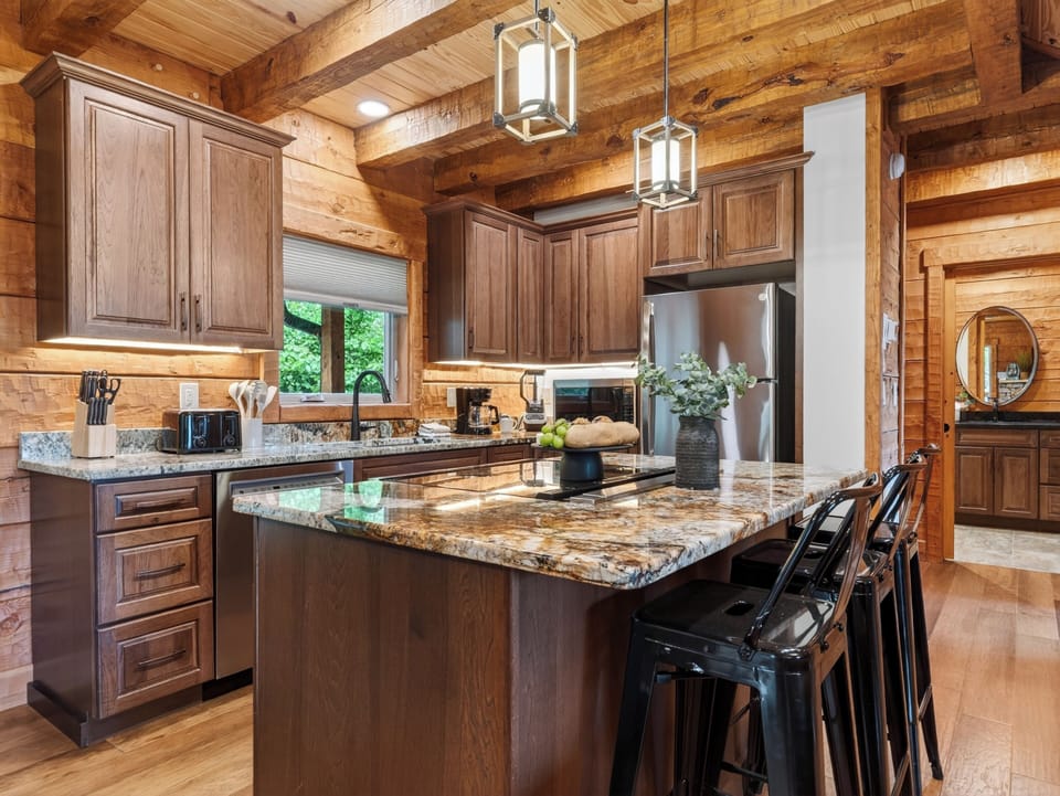 Chef’s kitchen with granite countertops, stainless steel appliances, and island seating.