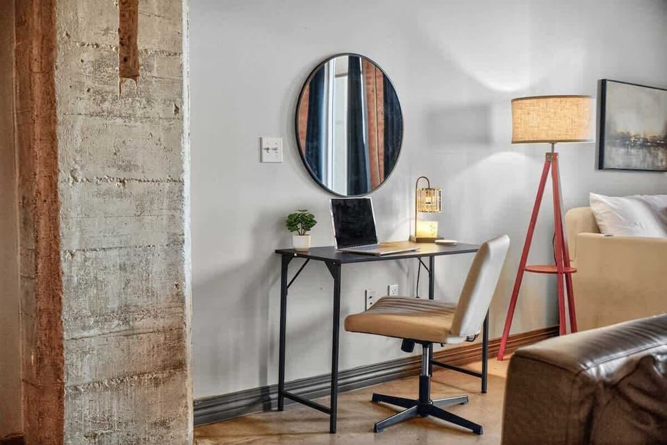 “Work-from-home ready” — A cozy desk nook with soft lighting and a round mirror, designed for productivity and comfort