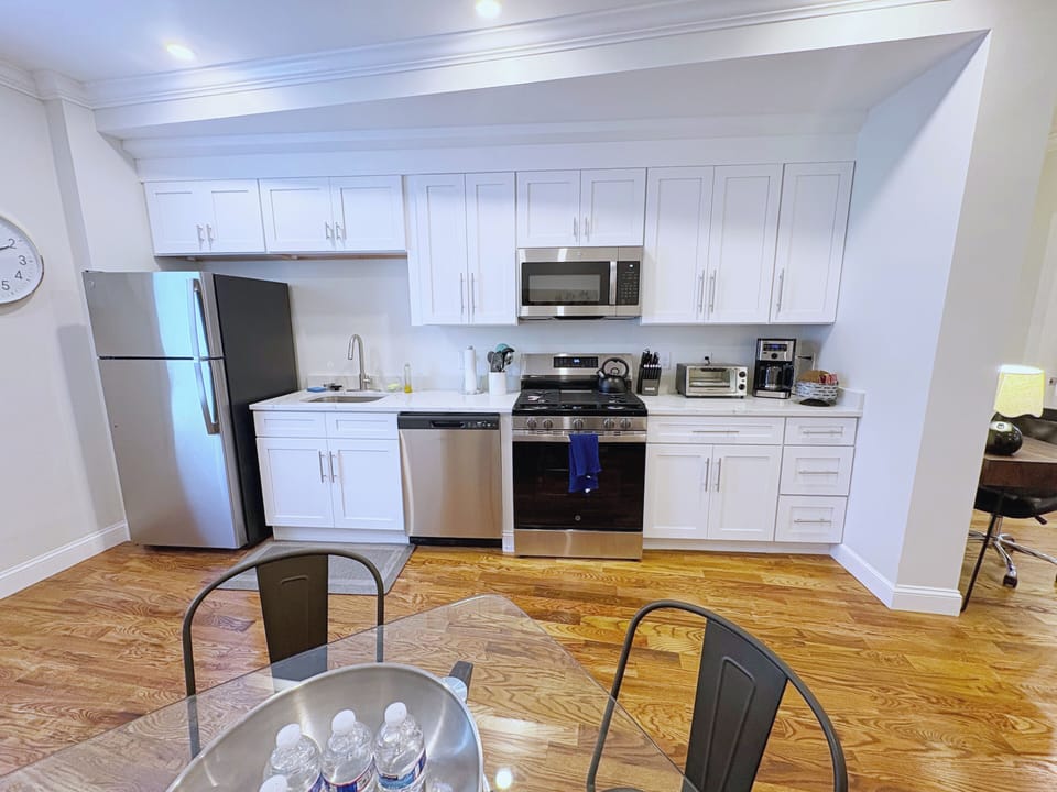 Modern kitchen with white cabinetry, stainless steel appliances