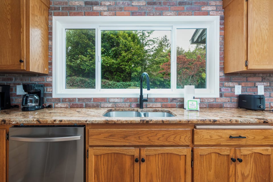 Your fully equipped kitchen features a garden view window, stainless appliances, and everything you'll need to prepare meals during your stay. Start each morning with coffee overlooking the lush greenery outside.