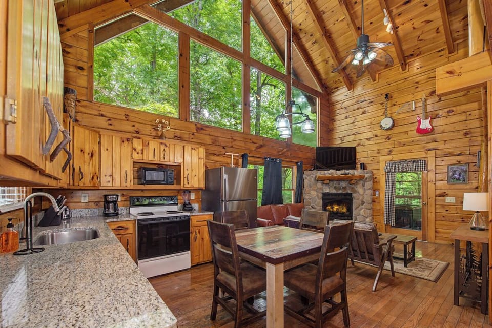 Sunlight streams through the towering windows, warming the rustic wood and inviting you to relax by the stone fireplace or gather around your dining table.