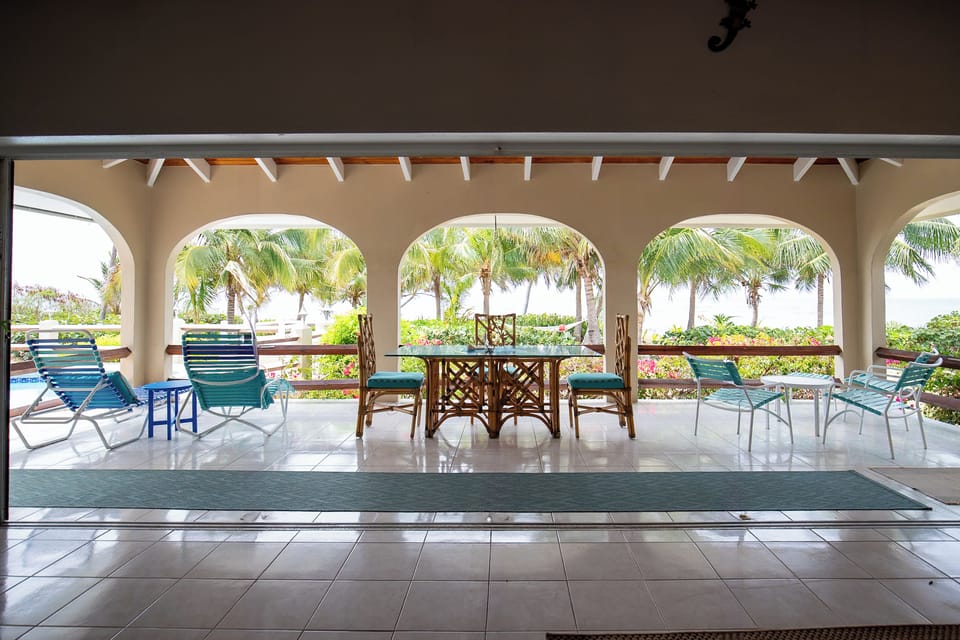 Covered patio and dining area with view of the water and pool area