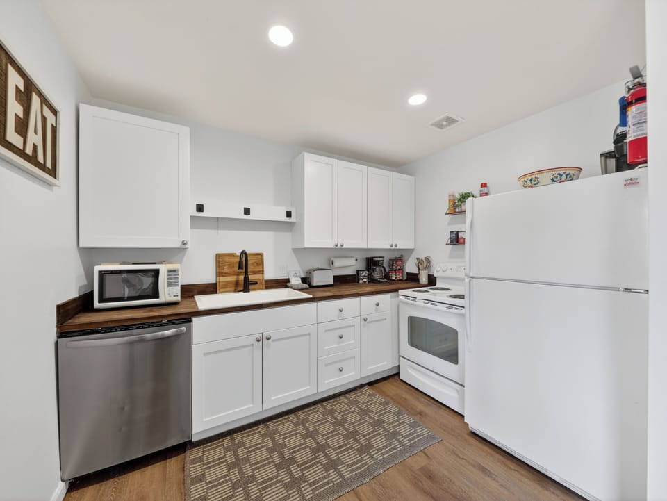 Your fully equipped kitchen has everything needed to prepare delicious home-cooked meals, featuring modern appliances and warm wood countertops in a bright, welcoming space.
