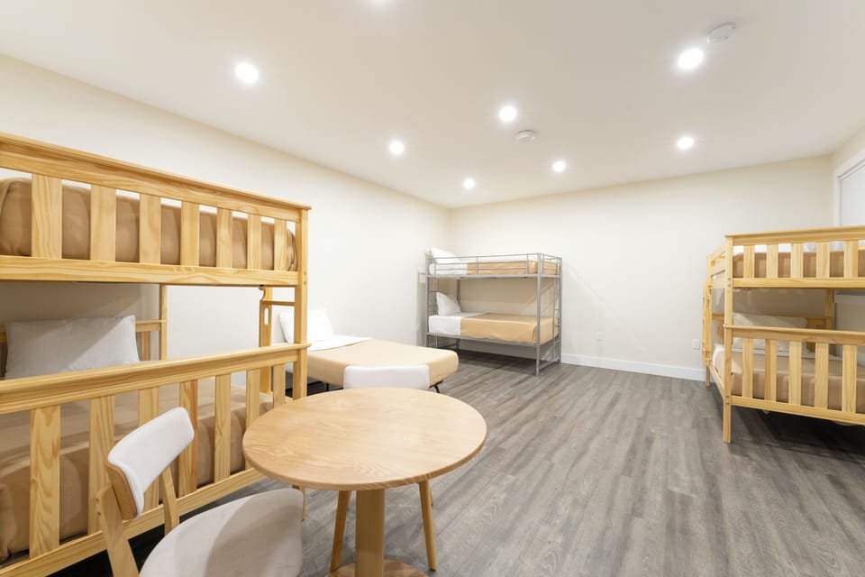 Bright shared bunk room with clean modern design, perfect for groups or families seeking comfortable, affordable lodging together.